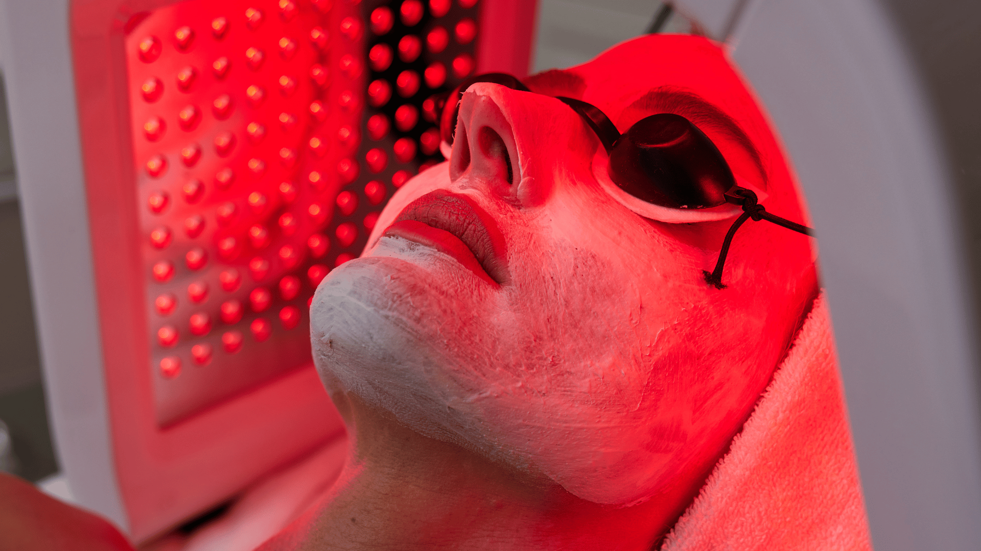 person under red light therapy receiving a n anti-aging skin treatment