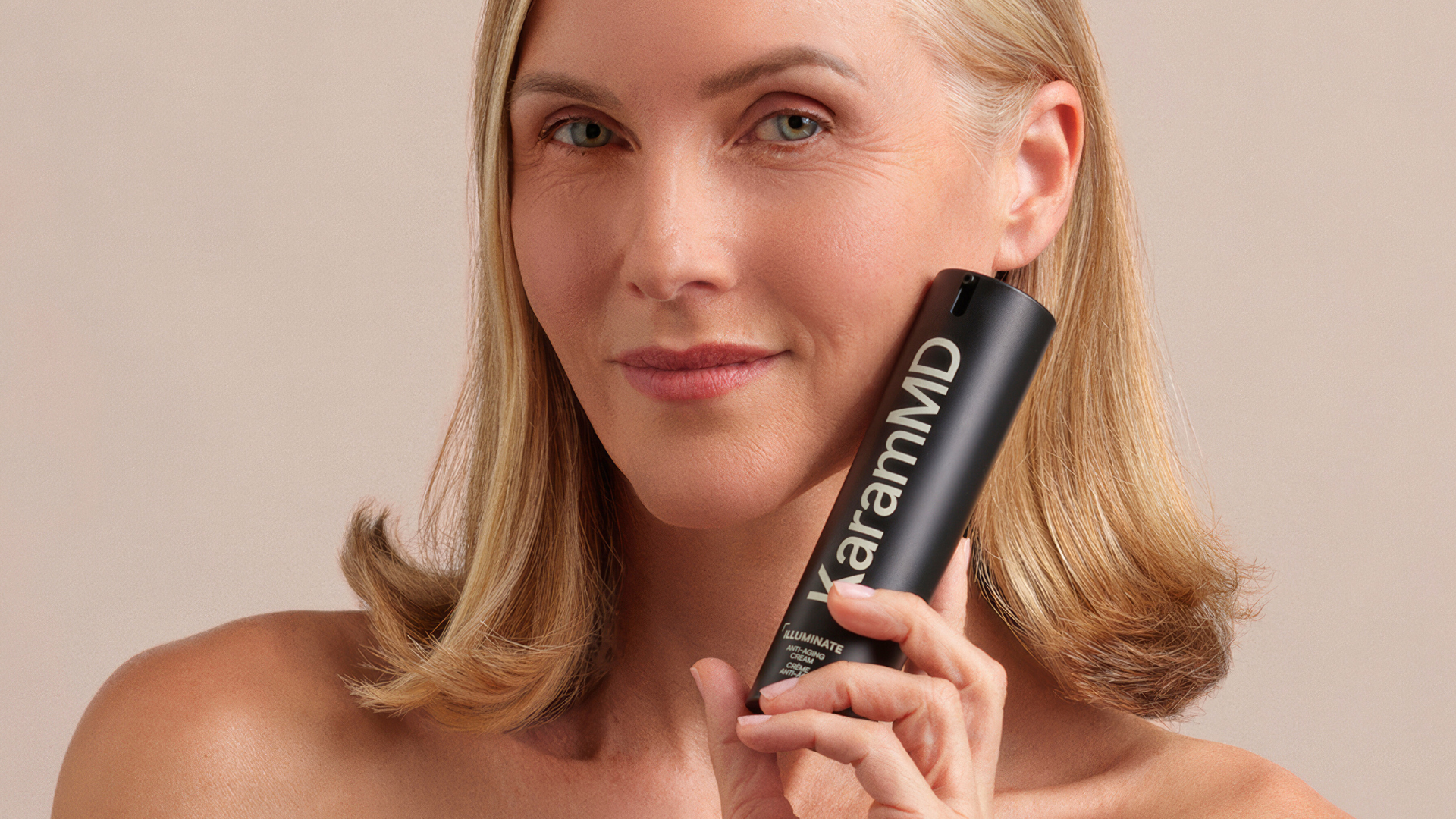Woman holding up Illuminate Anti-Aging Cream from KaramMD