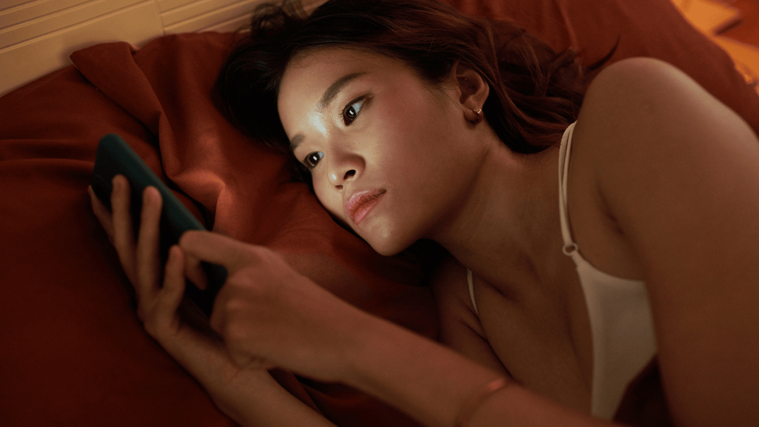 Woman looking at her phone, possibly being exposed to blue light
