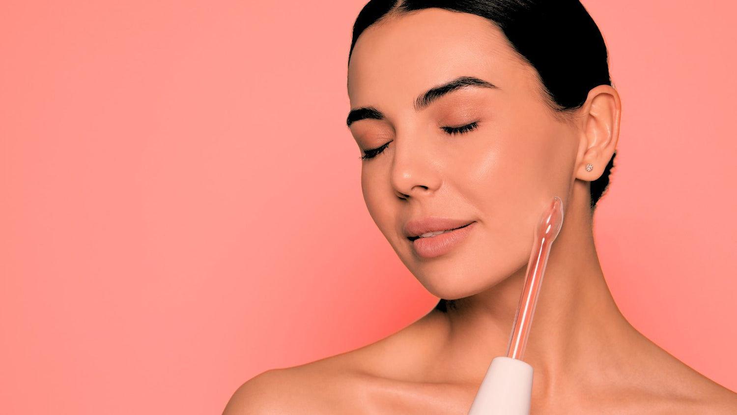 woman with youthful skin using red light wand