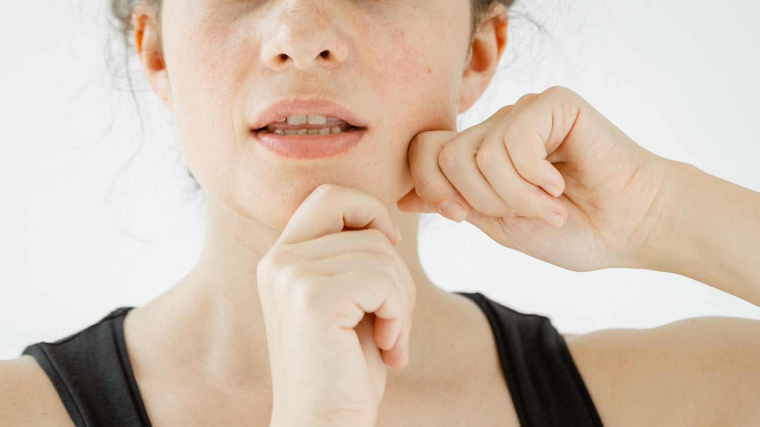 woman performing face yoga exercises on lower face