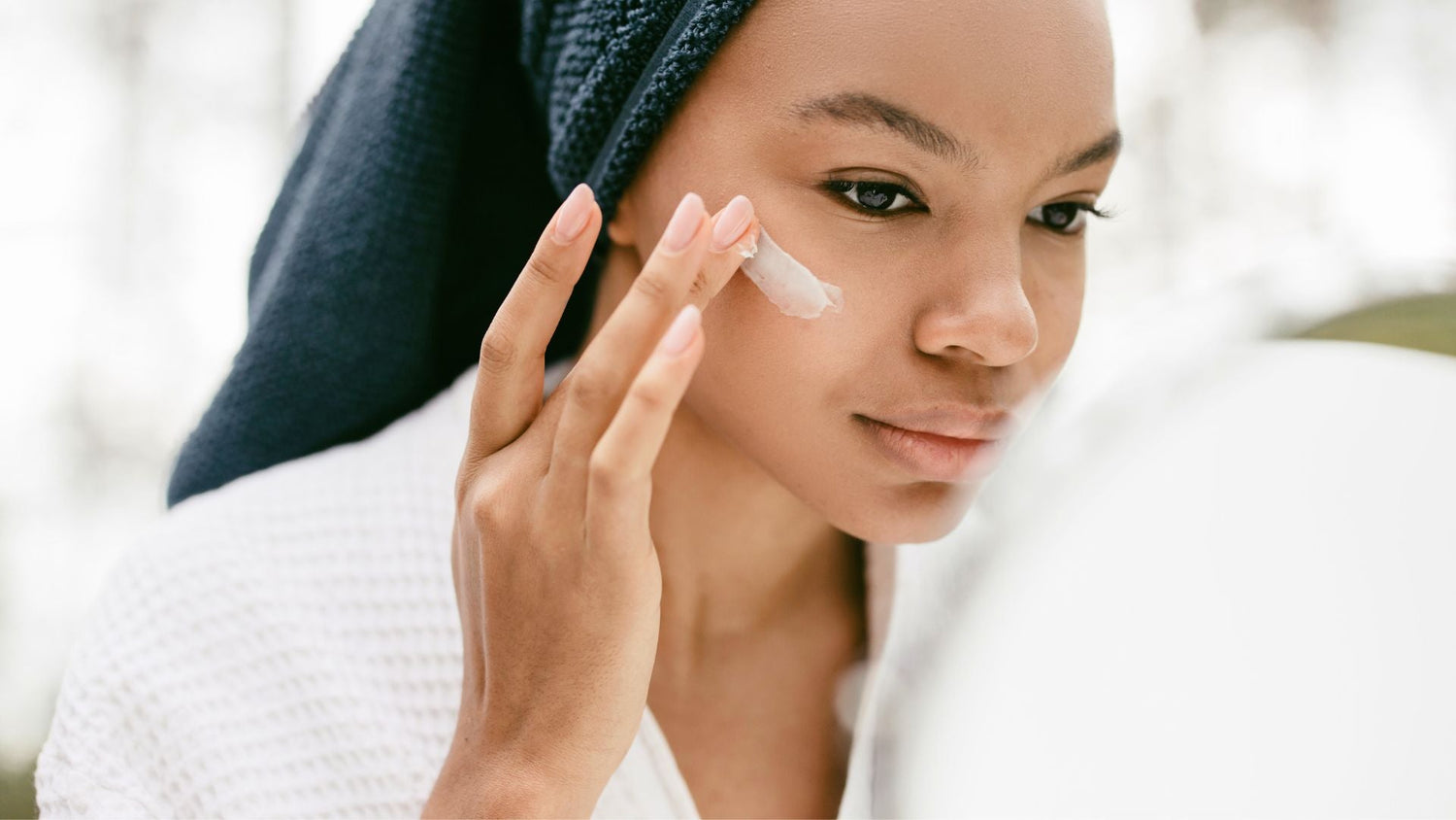 Woman applying skincare and eye cream