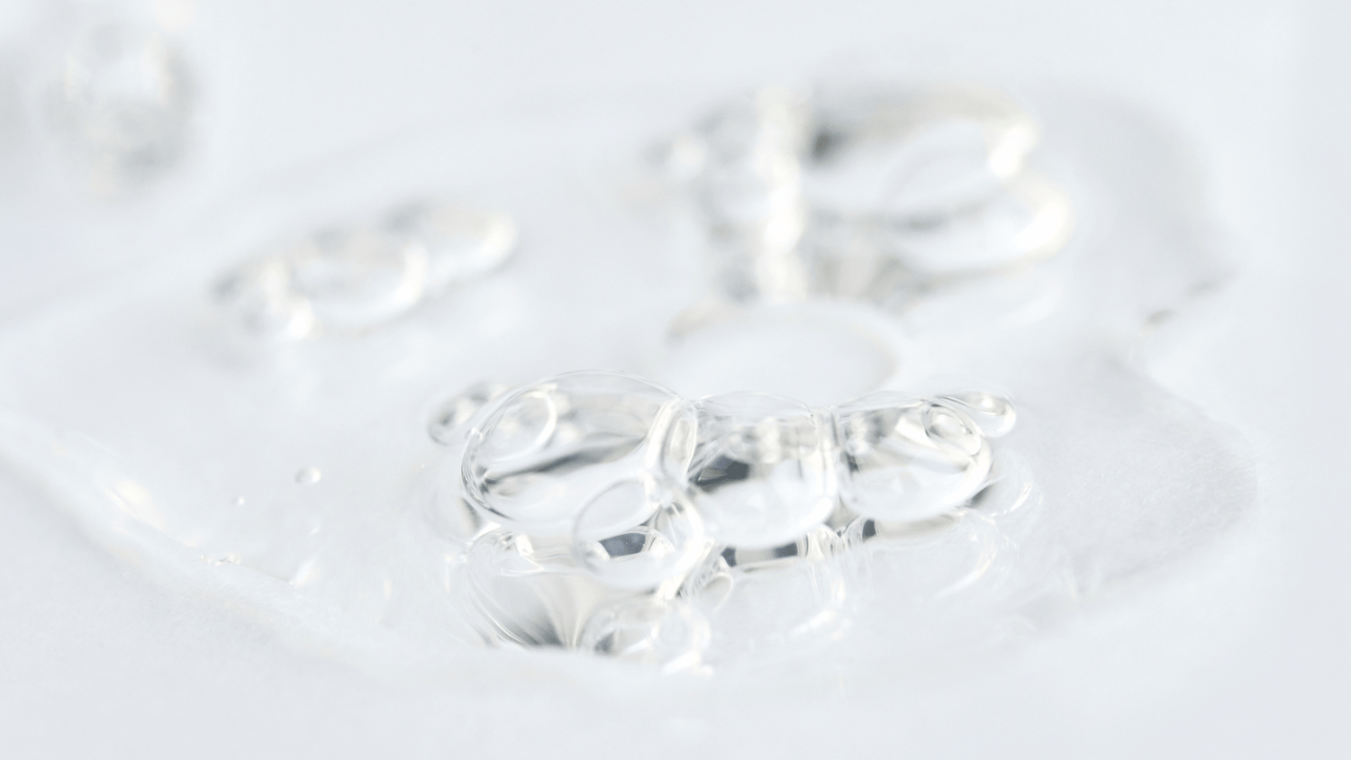 Clear hydrating skincare gel texture spread across a white surface.