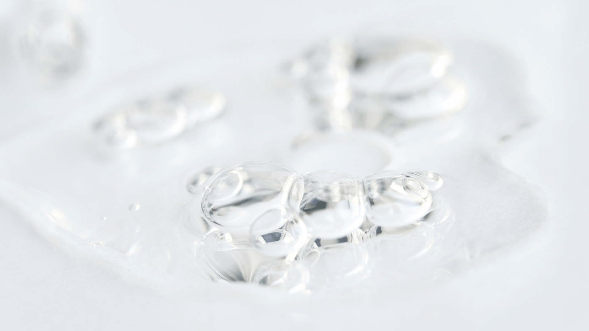 Clear hydrating skincare gel texture spread across a white surface.