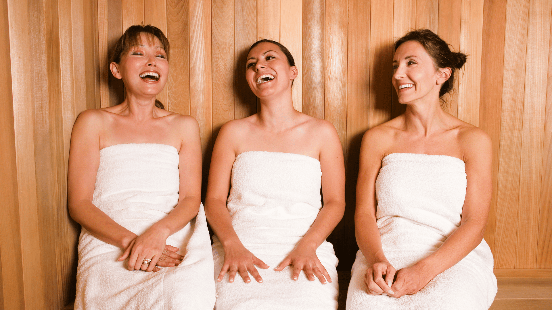 Three beautiful, smiling women enjoying the benefits of sauna