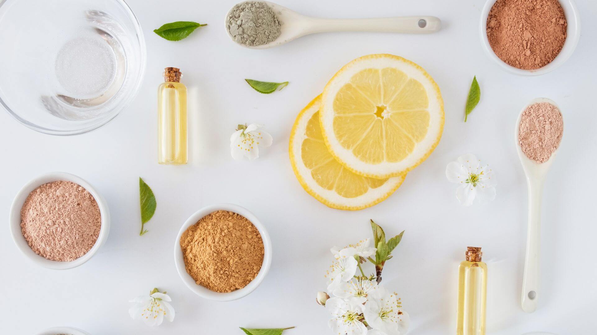 Skincare ingredients for brightening dull skin, including vitamin C, exfoliation, and other liquid ingredients like retinol and hyaluronic acid in bottles on a clean white background.