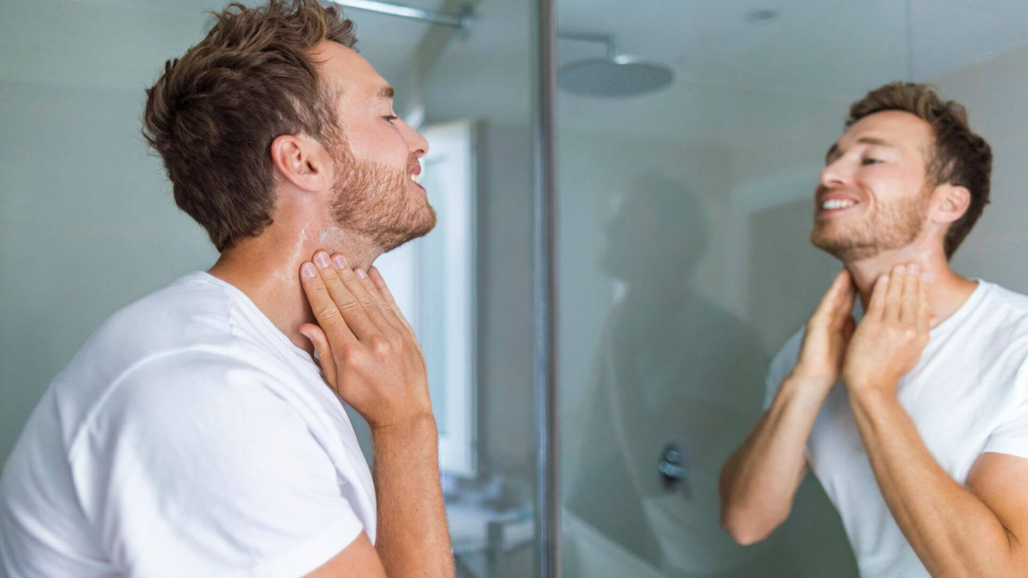 An adult man washing his face with skincare products.