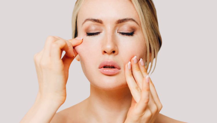 Woman pinching and pulling face