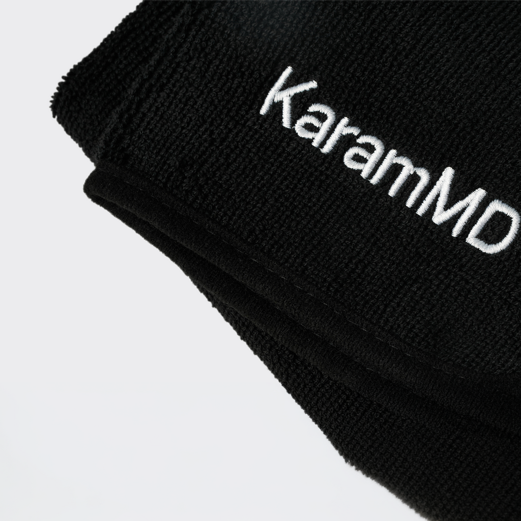 Black face towel with 'KaramMD' embroidered on a light gray background